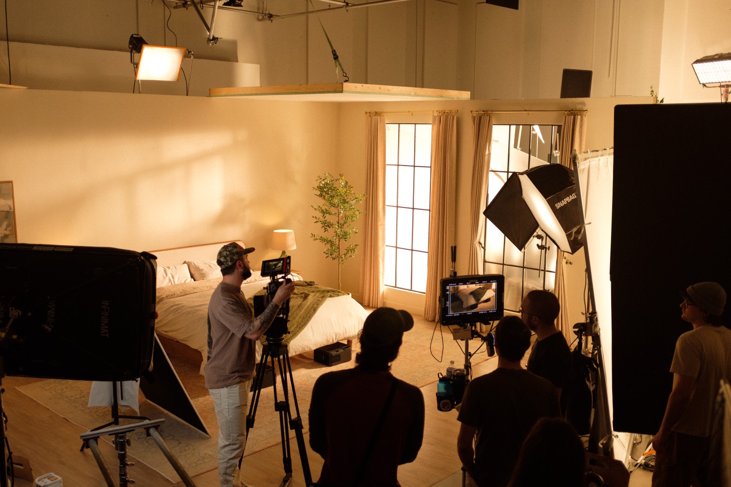 Wide view of the bedroom set build inside the studio, crew and monitors on the floor.