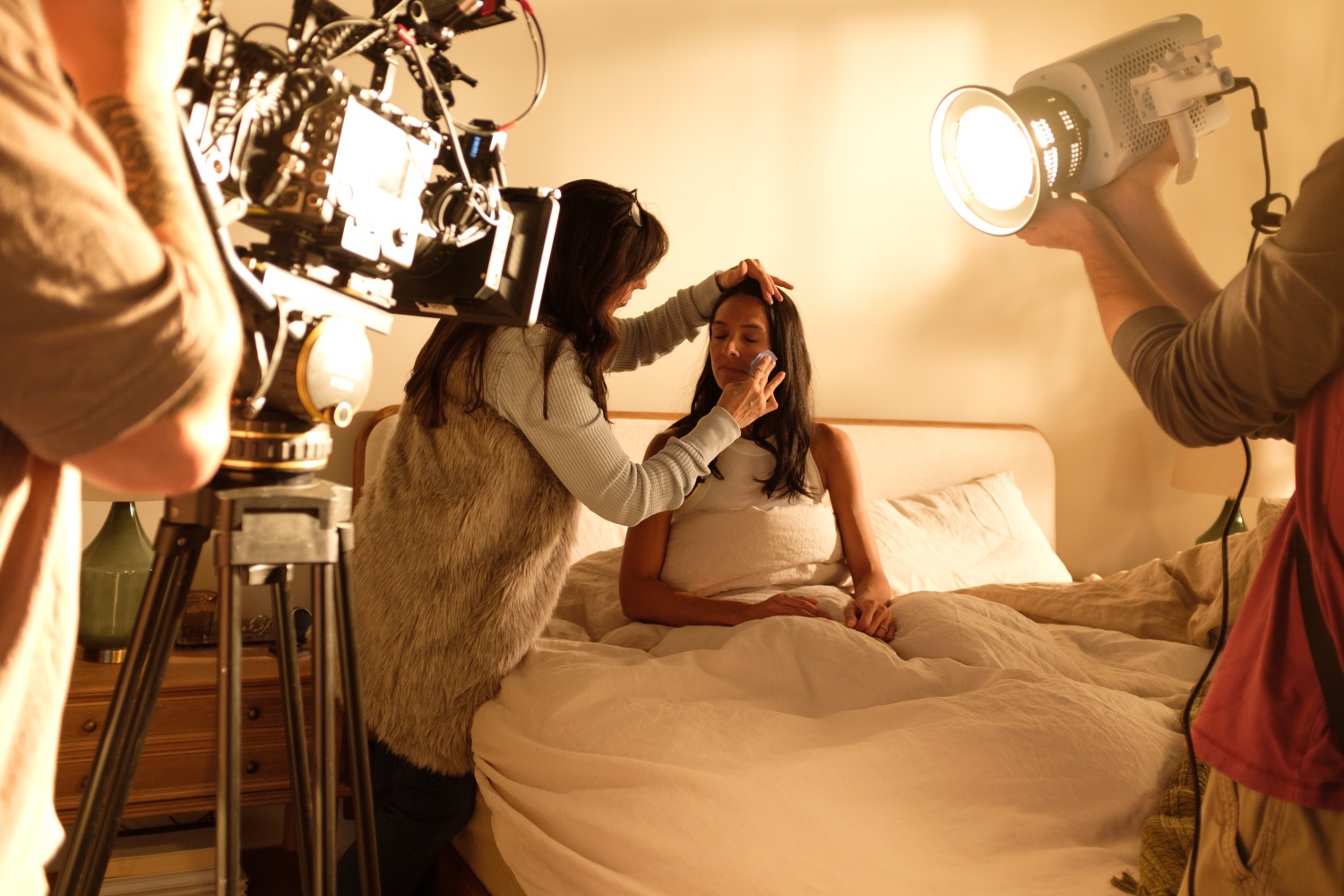 Talent on set with a stylist and a camera and light rig.