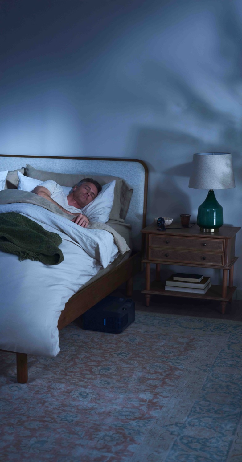 Man asleep with the control unit tucked under the bed.