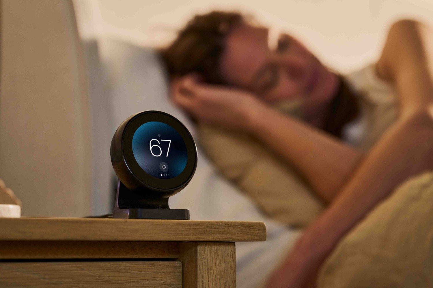 Bedside control hub showing 67 degrees with a sleeper behind it.